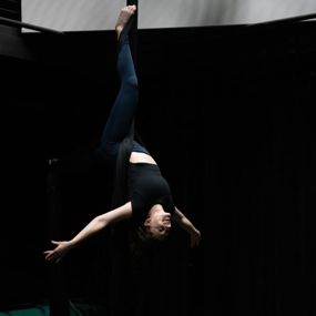 Sydney Pereira hanging upside down on aerial fabrics
