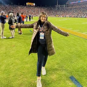Mattie Whitney poses on the field at Jordan Hare Stadium