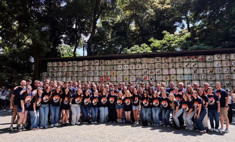Group of Auburn band students in front of a wall in Japan