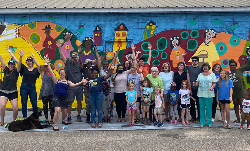 Living Democracy participants pose in front of mural