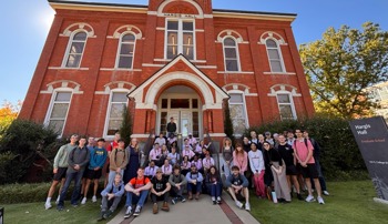 Aviation Leadership students and BraveHeart artists pose for a group photo outside Hargis Hall