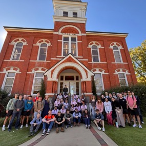 Aviation Leadership students and BraveHeart artists pose for a group photo outside Hargis Hall