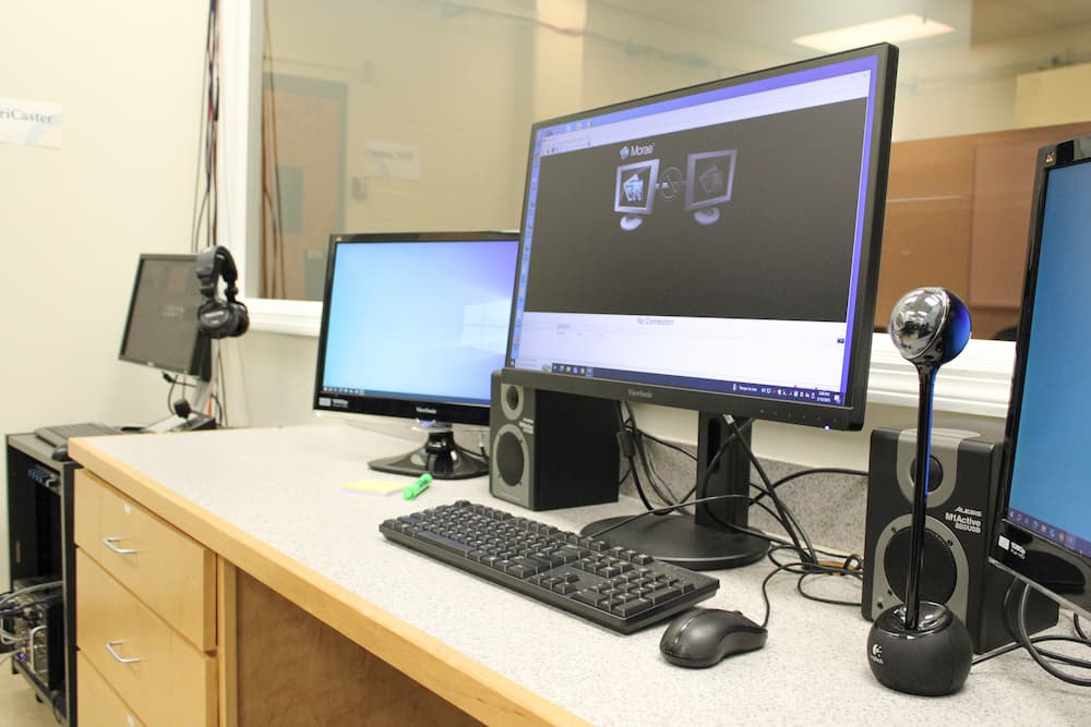 A photo of computers in the control room running the MORAE usability testing program. 