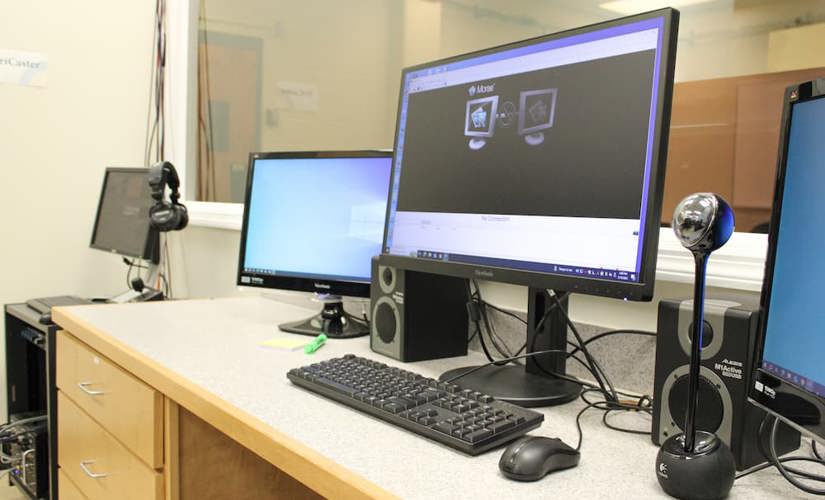 A photo of computers in the control room running the MORAE usability testing program. 