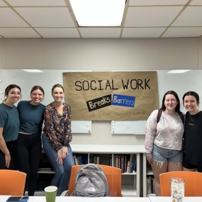Student standing in front of sign that says social work