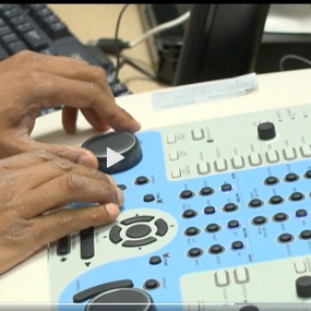 a pair of hands operate audiology testing equipment