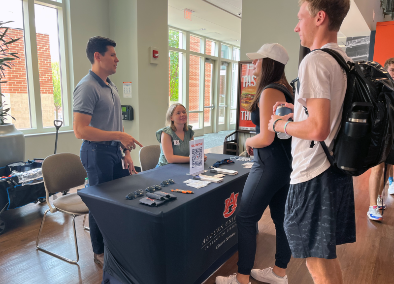 Students talk to Career Services staff at a table display