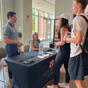 Students talk to Career Services staff at a table display