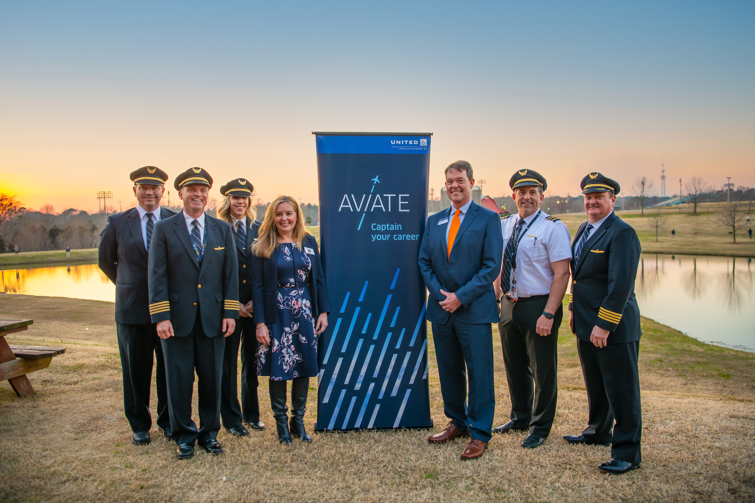 College of Liberal Arts Interim Dean Ana Franco-Watkins stands with United pilots in front of Aviate Captain your Career sign