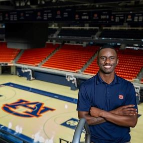 Dre Gaines posing for photo at the Auburn basketball arena