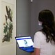 Katelyn Zeeveld compares artwork in gallery with image on her laptop