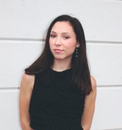photo of woman with dark hair standing against a white background