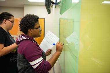 Students working at white board in class