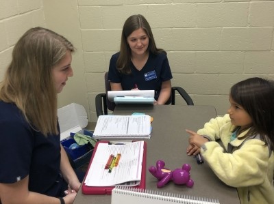 Speech-language pathologists speaking with child