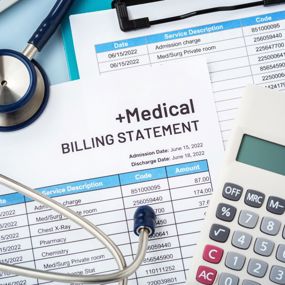 Expensive medical bills crowding a tabletop alongside a calculator and stethoscope