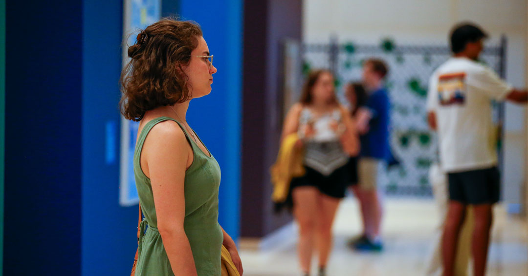 Students look at art objects in a museum gallery
