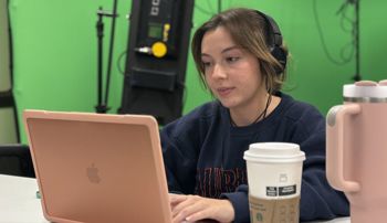 Auburn journalism student calling reporters and working on computer during Election Night