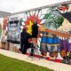 Wendy DesChene installing a 50-foot mural depicting the history and culture of Poarch Creek Indians