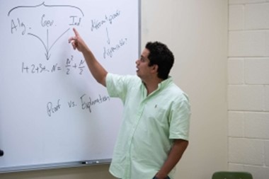 Professor in a classroom teaching at a board