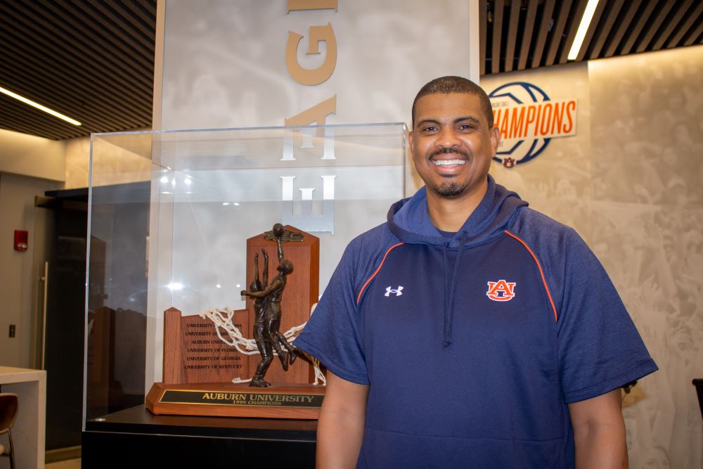 Bryant Smith posing beside 1999 SEC Championship trophy.