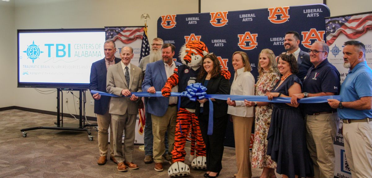 Representatives from Alabama and Auburn cut the ribbon at the Opelika TBI Center location