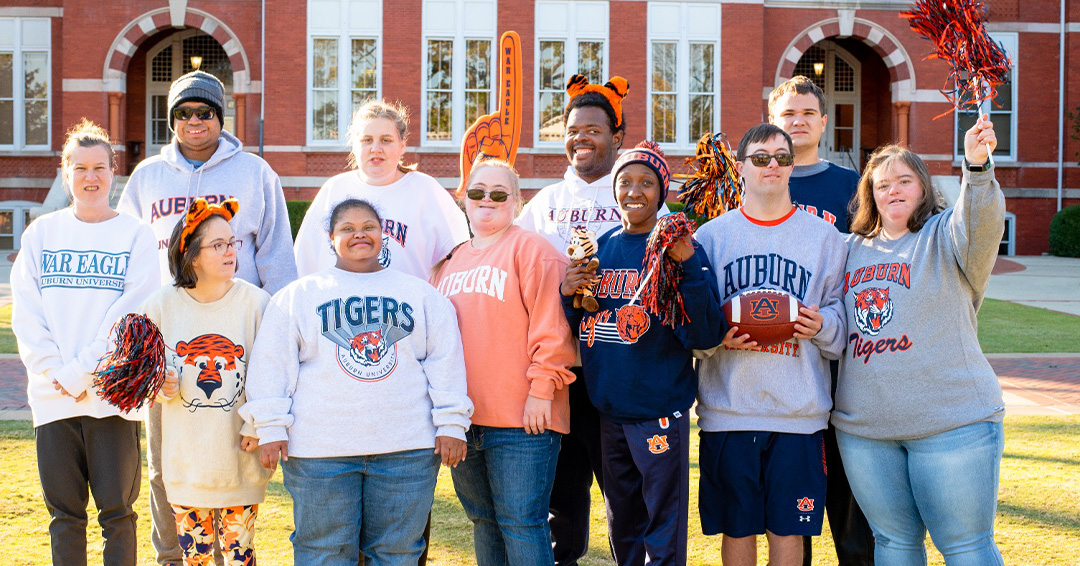 The BraveHeart community ambassadors wear Auburn sweatshirts in front of Samford Hall