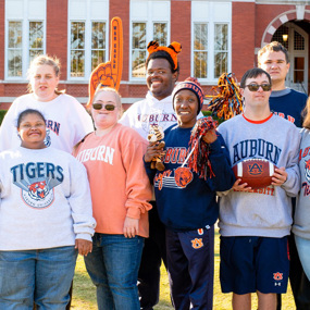 The BraveHeart community ambassadors wear Auburn sweatshirts in front of Samford Hall
