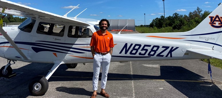 Kadon Luke standing in front of plane at the Auburn airport