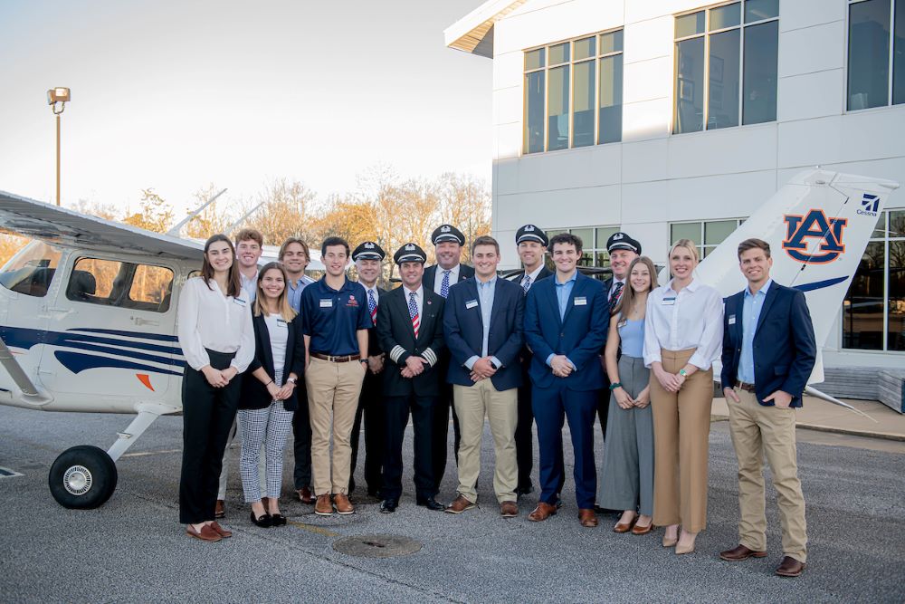 Auburn students and Southwest pilots stand in front of Auburn airplanes at the Destination 225 program celebration