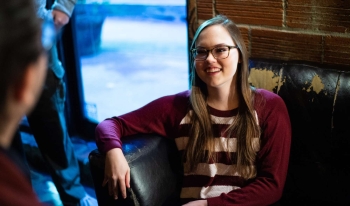 Girl sitting on a couch talking to someone