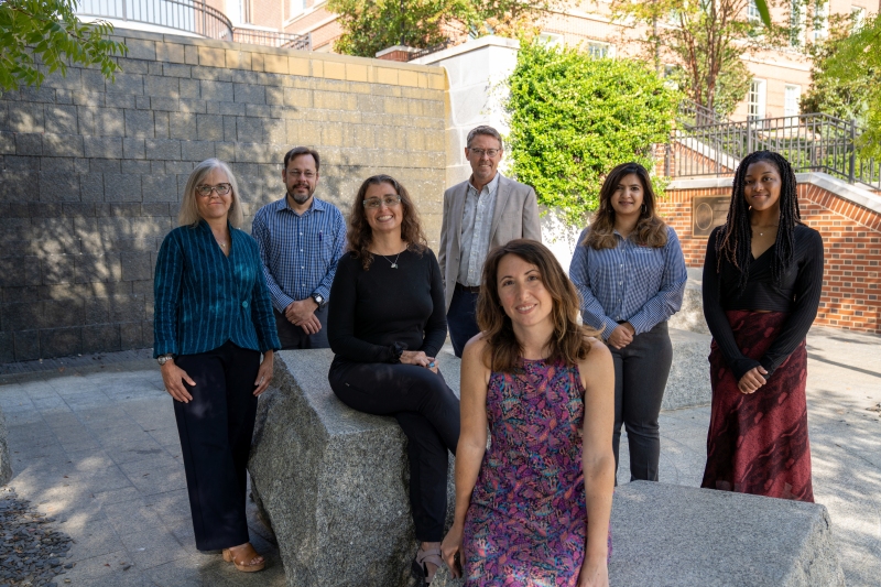 Group of faculty members standing next to a wall