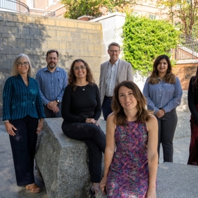 Group of faculty members standing next to a wall
