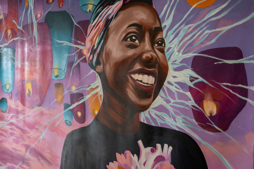 Mural featuring a smiling student surrounded by candles