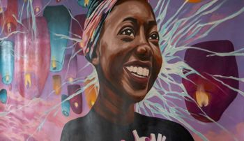 Mural featuring a smiling student surrounded by candles