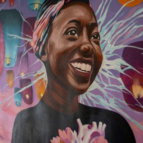 Mural featuring a smiling student surrounded by candles