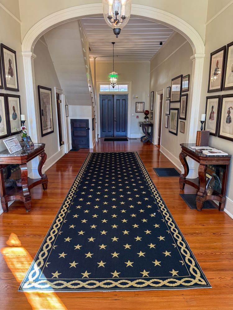 The Pebble Hill entryway, decorated with historic maps, Creek portraits and antique furniture