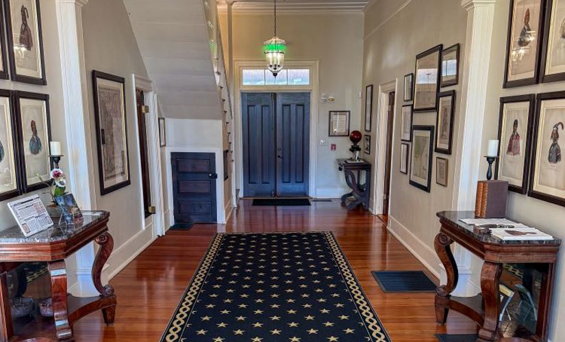 The Pebble Hill entryway, decorated with historic maps, Creek portraits and antique furniture