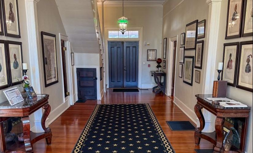 The Pebble Hill entryway, decorated with historic maps, Creek portraits and antique furniture