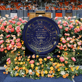 Roses around a podium with an Auburn University seal in the center of it