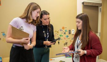 Graduate student clinicians discussing treatment options at CARTT