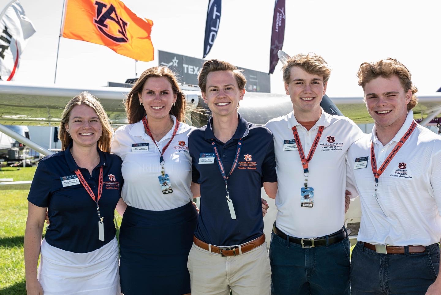 Student standing next to Aubie and a pilot 