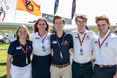 Student standing next to Aubie and a pilot 