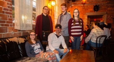 Group of students sitting with a professor on a couch