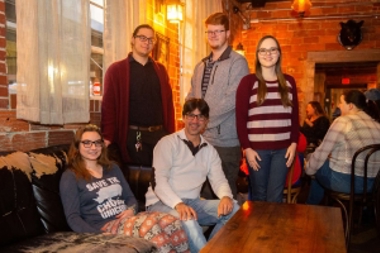 Group of students sitting with a professor on a couch