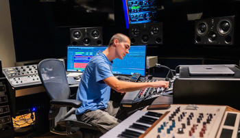 Student controlling sound equipment in the Lucky Man Studio