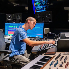 Student controlling sound equipment in the Lucky Man Studio
