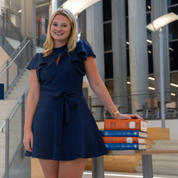Isabella Dee with books in the RBD Library at Auburn