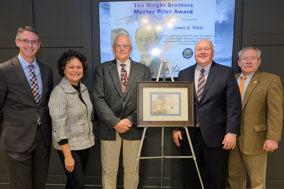 James Witte stands with Auburn leadership and a framed Wright Brothers award