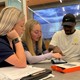 Auburn speech-language pathology students show a TBI Camp participant how to use assistive technology