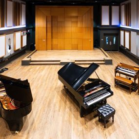 three pianos in a large recording studio space